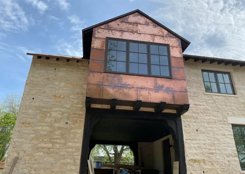 Copper metal panel facade on a stone building for Roof Repair in Scenic Oaks